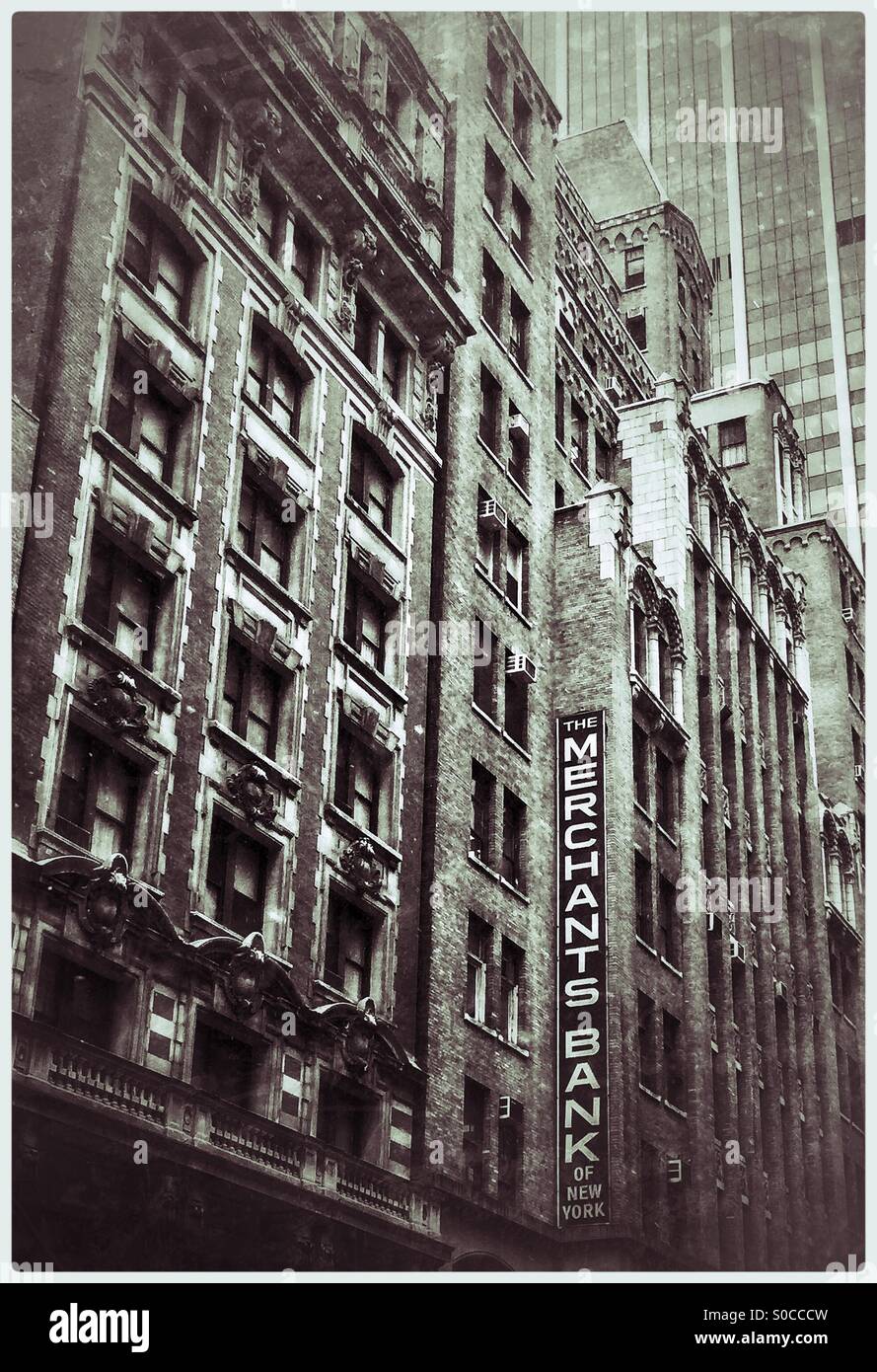Merchant Bank di New York il vecchio segno sul vecchio edificio con grattacielo nel retro di massa. In bianco e nero il filtro creativo. - Immagine stock catturata con smartphone