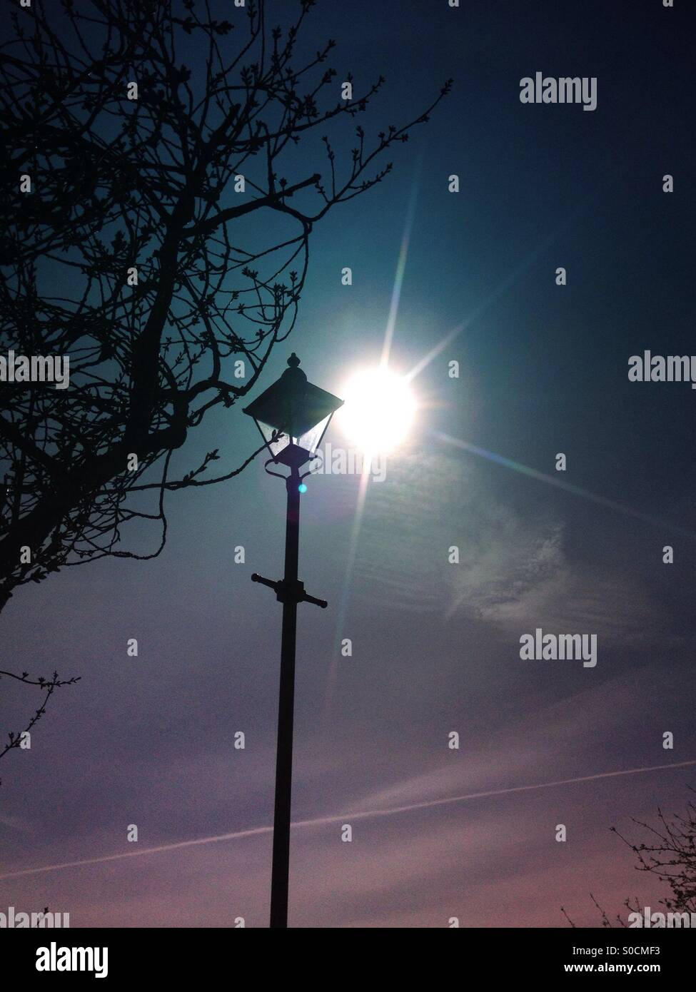 Sole che splende dietro la vecchia via la luce - Immagine stock catturata con smartphone