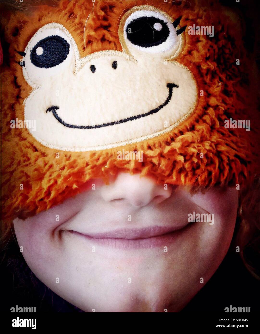 Sorridente ragazza di scimmia che indossa la maschera per gli occhi Foto Stock
