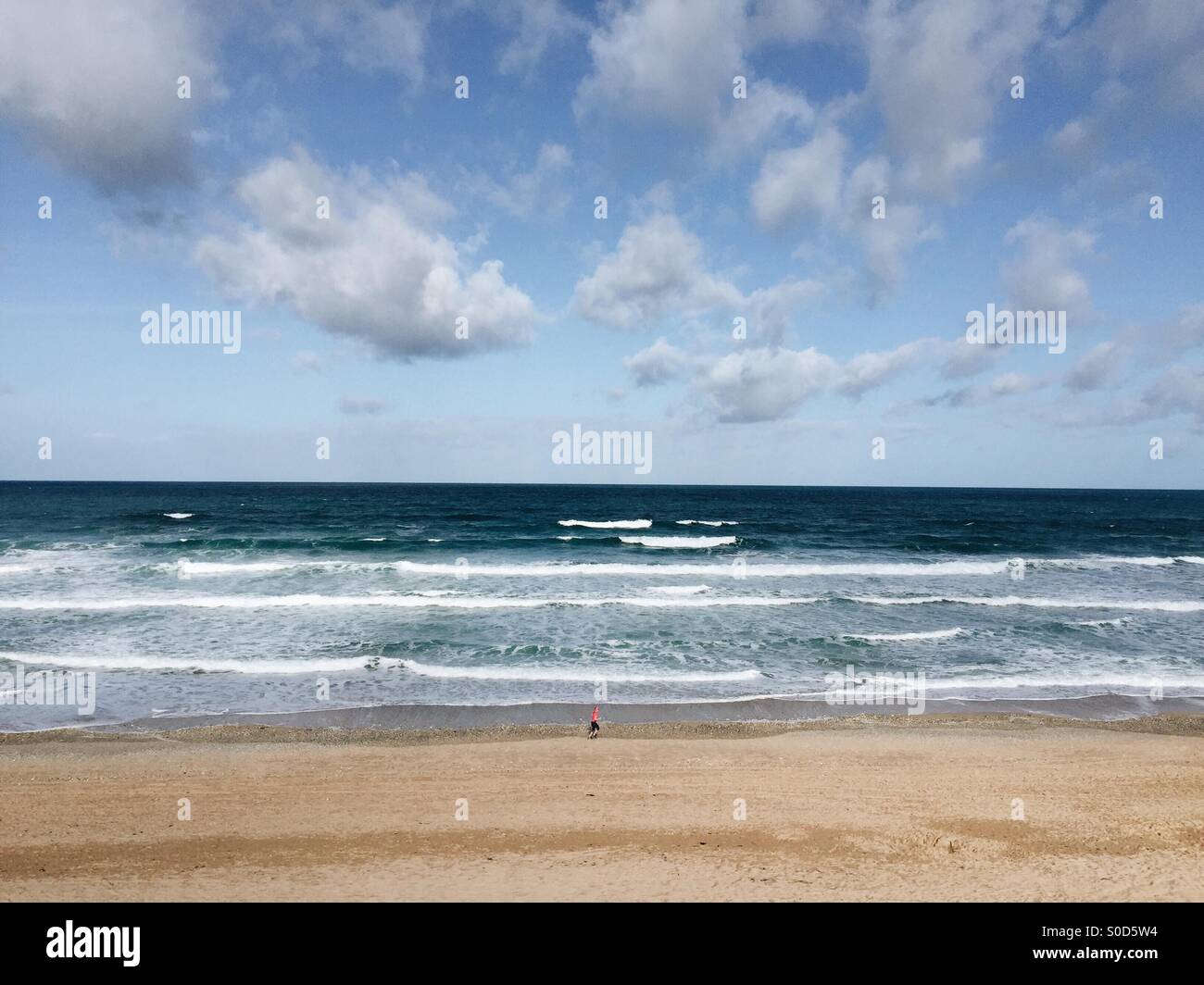 Lone runner su Fistral Beach, Newquay Cornwall Foto Stock
