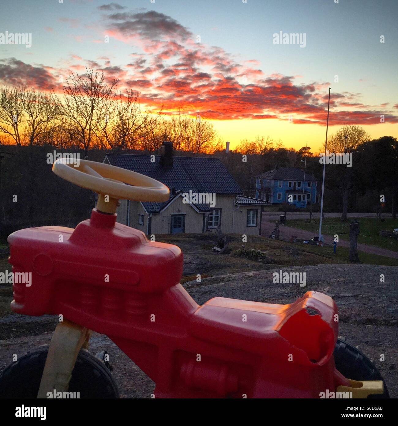 Giocare al di fuori tutto il giorno. Giocattoli per bambini a sinistra in giardino al tramonto. Uno stile di vita sano in Scandinavia. - Immagine stock catturata con smartphone
