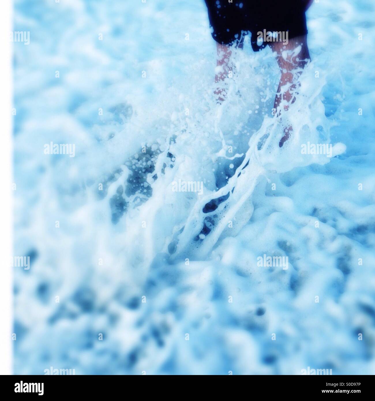 Acqua schiumosa streaming intorno e schizzi di un uomo per le gambe Foto Stock