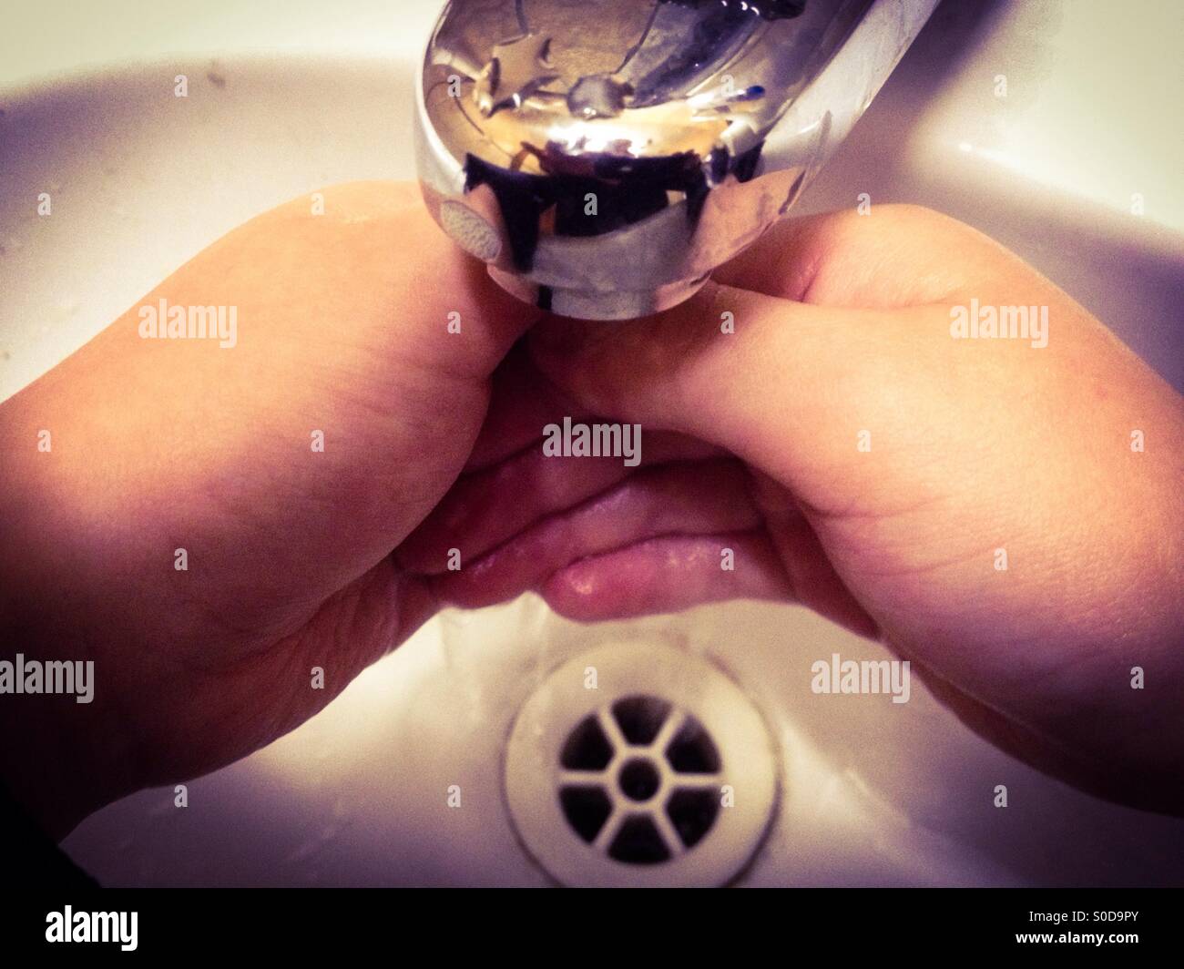 Un bambino lavarsi le mani in un ristorante fast food. - Immagine stock catturata con smartphone