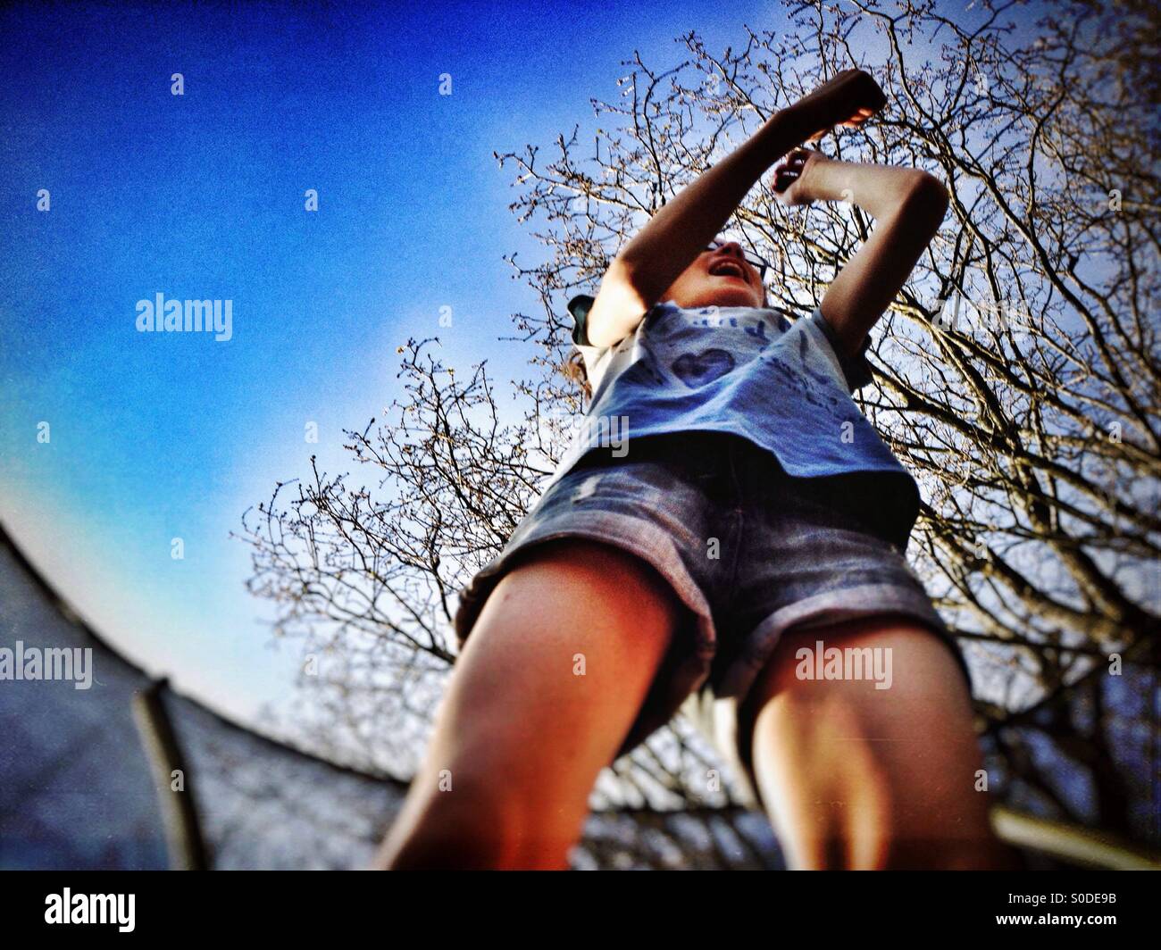 Ragazza giovane rimbalzare sul trampolino Foto Stock