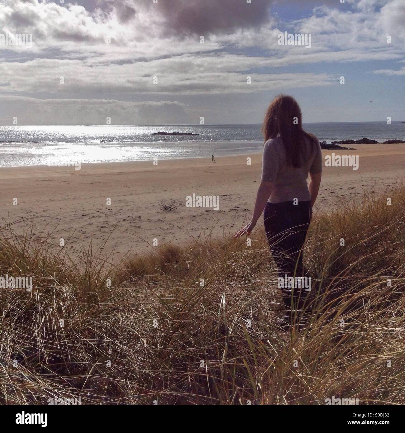 La donna che si affaccia su una spiaggia Foto Stock