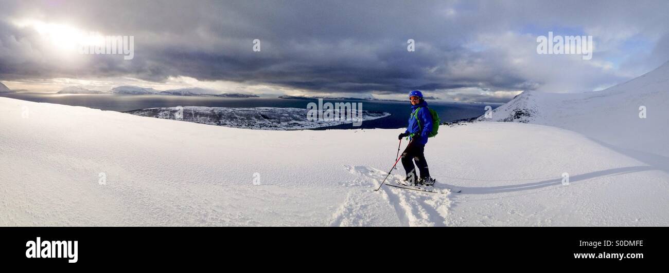 Sciatore e drammatico paesaggio di montagne e fiordi, Alpi Lyngen, arctic Norvegia Foto Stock