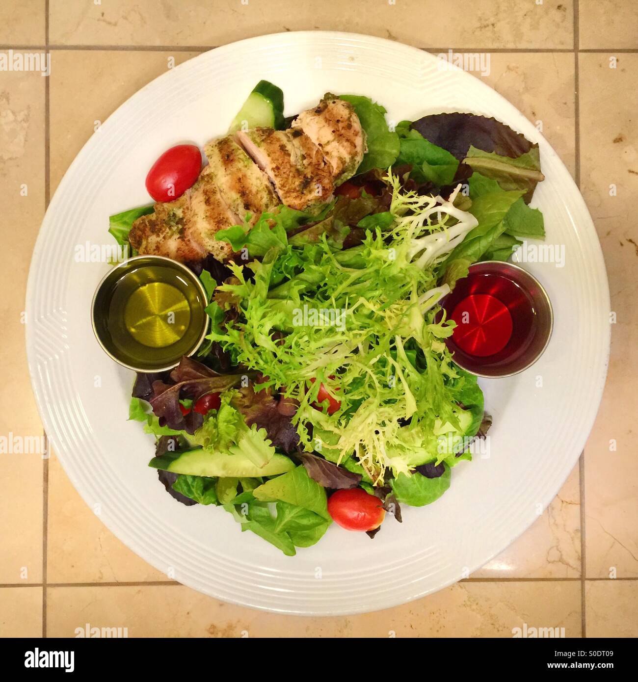 Una insalata possono essere artistico, colorato e simmetrica. Pollo alla griglia, verdure miste, aceto e olio. Foto Stock