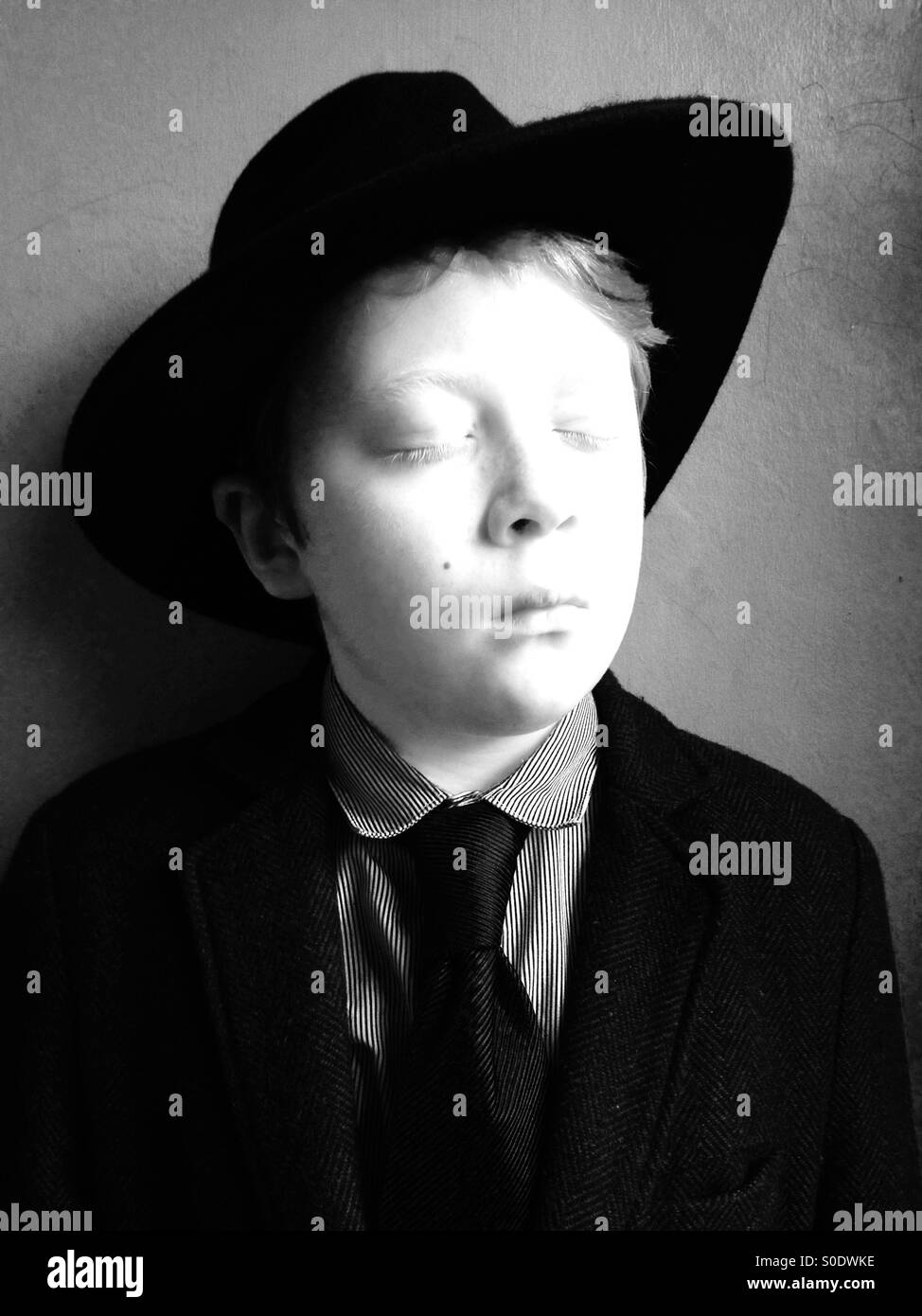 Ritratto di un 10-anno vecchio ragazzo che indossa un cappello trilby e tuta Foto Stock