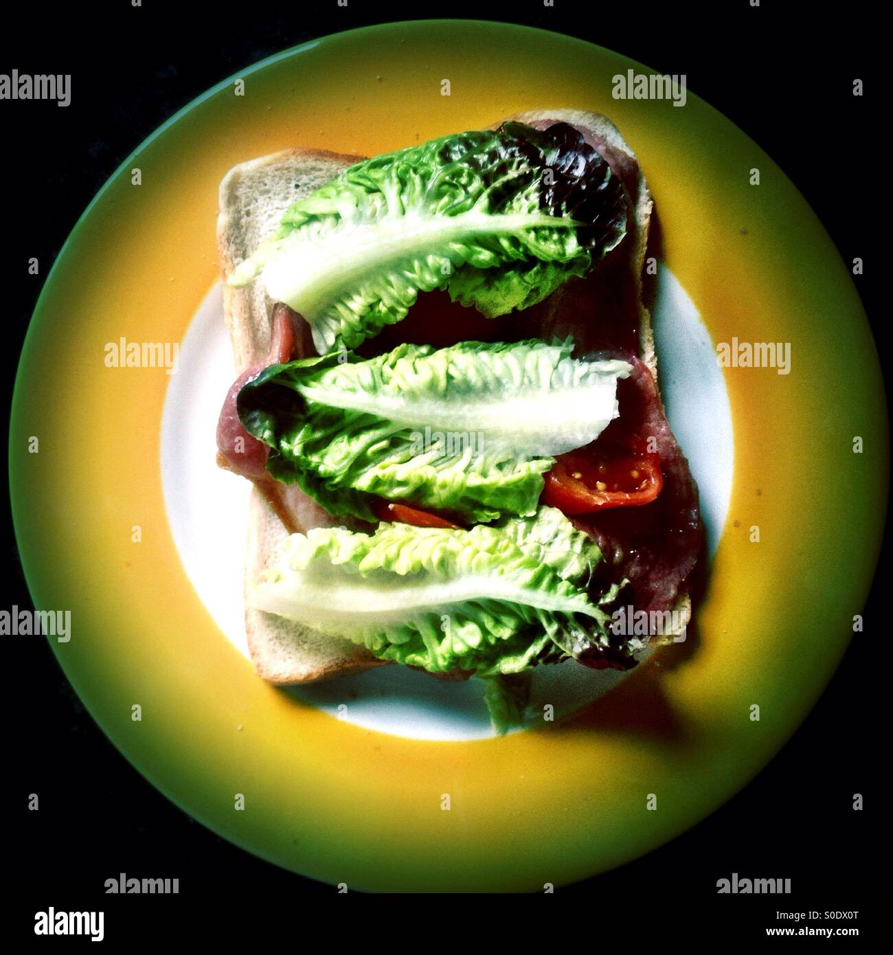 La realizzazione di una pancetta, lattuga e pomodoro sandwich. - Immagine stock catturata con smartphone