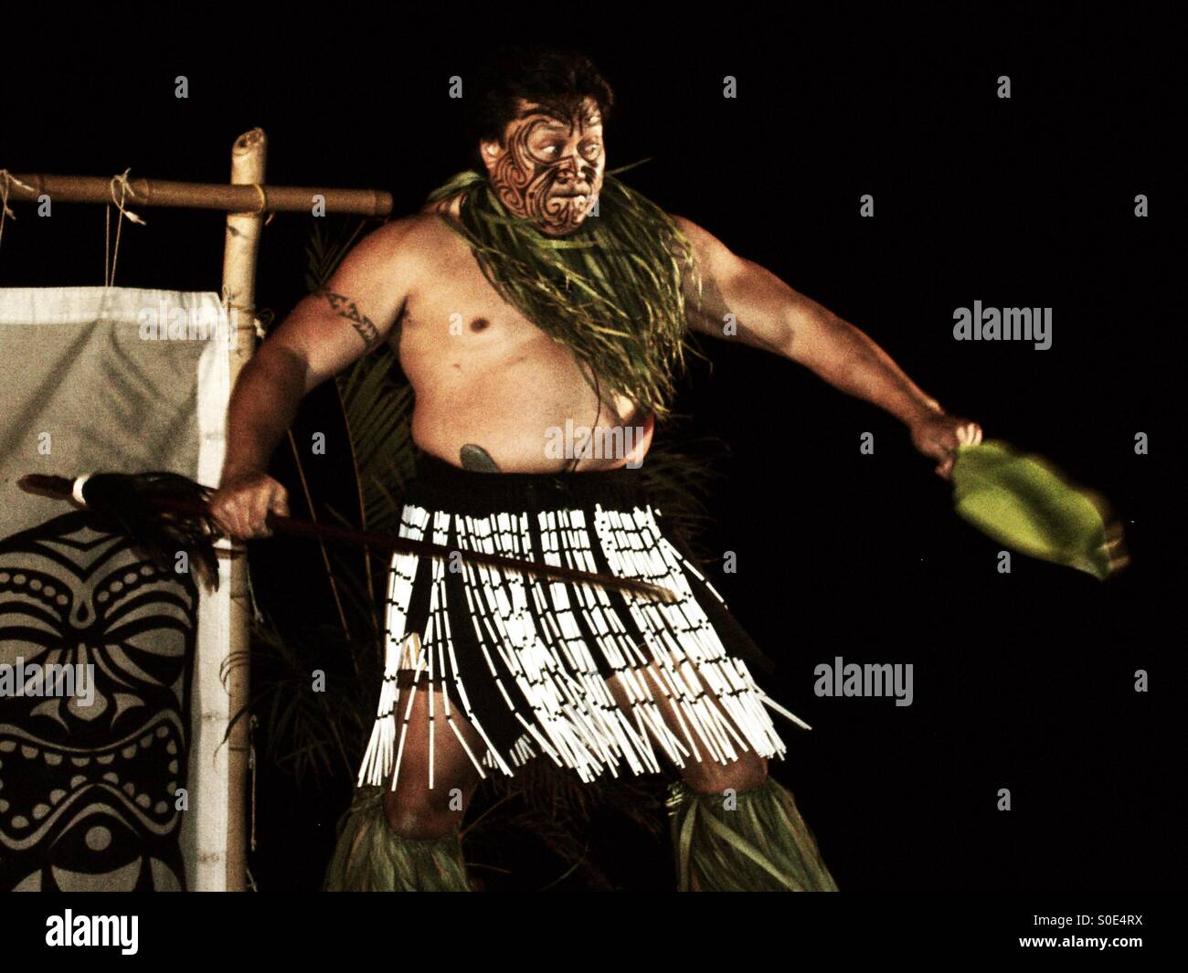Guerriero hawaiano esorcizza gli spiriti maligni attraverso la danza rituale, canti e combattimenti - Immagine stock catturata con smartphone
