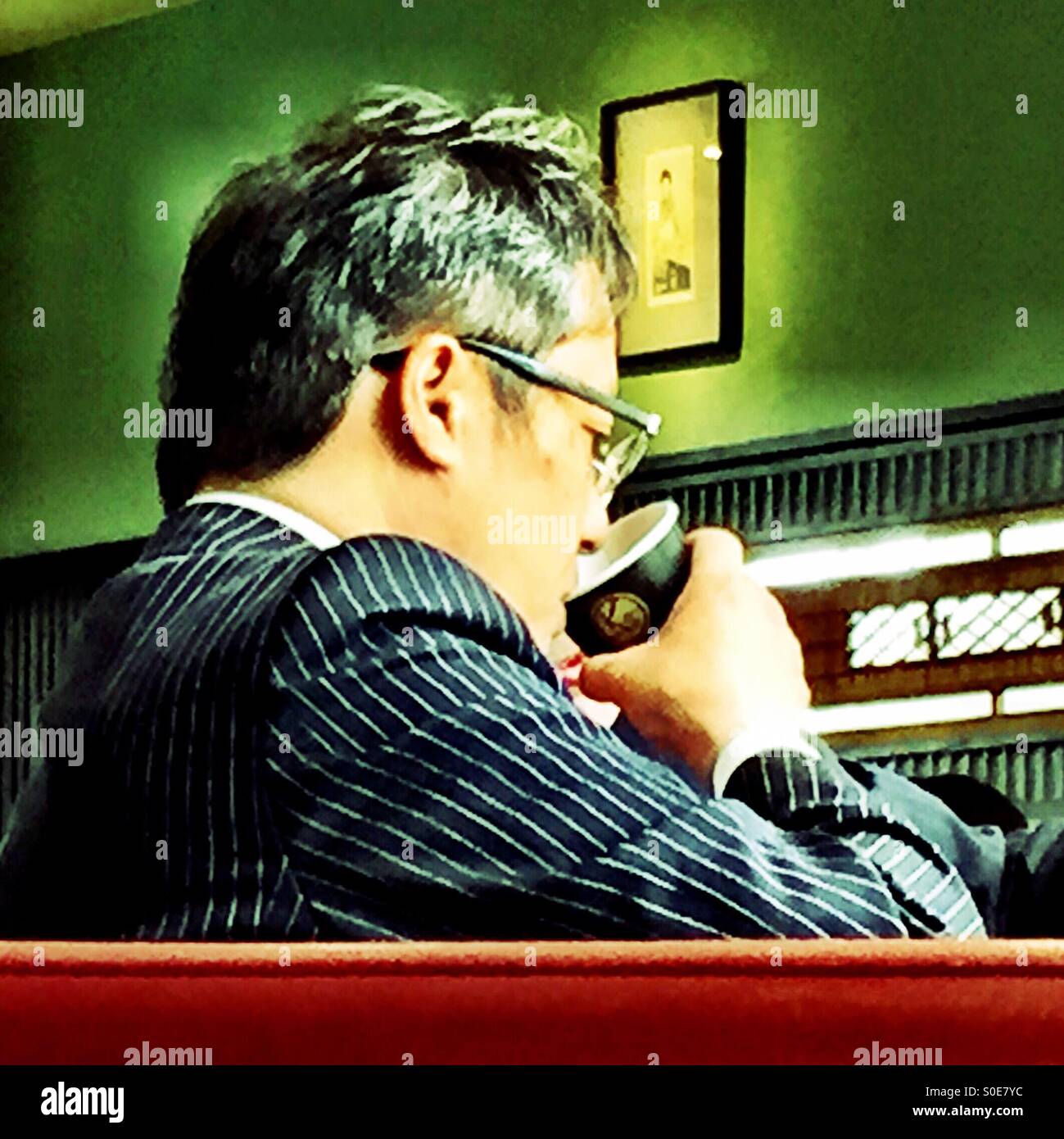 Imprenditore per finire il suo caffè durante la colata di uno più occhio rapido sul suo note della riunione - Immagine stock catturata con smartphone