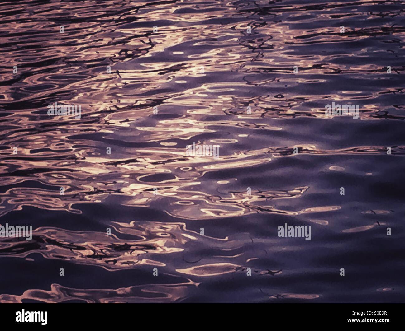 Una leggera brezza sull'acqua provoca piccoli increspature di cattura e di giocare con la luce. Foto Stock