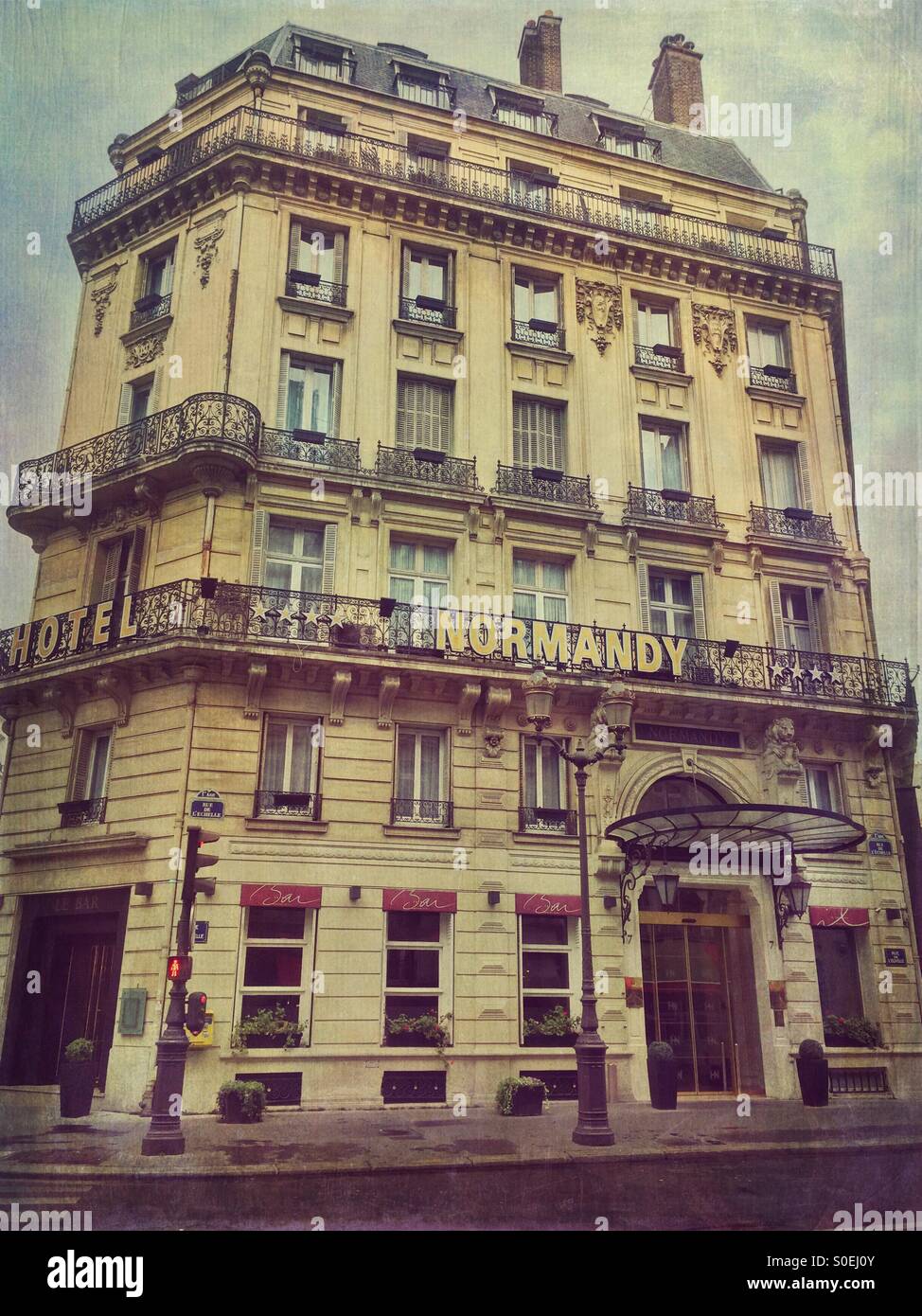 Vista di Hotel Normandy, situato nel centro storico di Parigi, Francia. Antiquariato, look retrò con l'annata di Grana carta overlay. Foto Stock