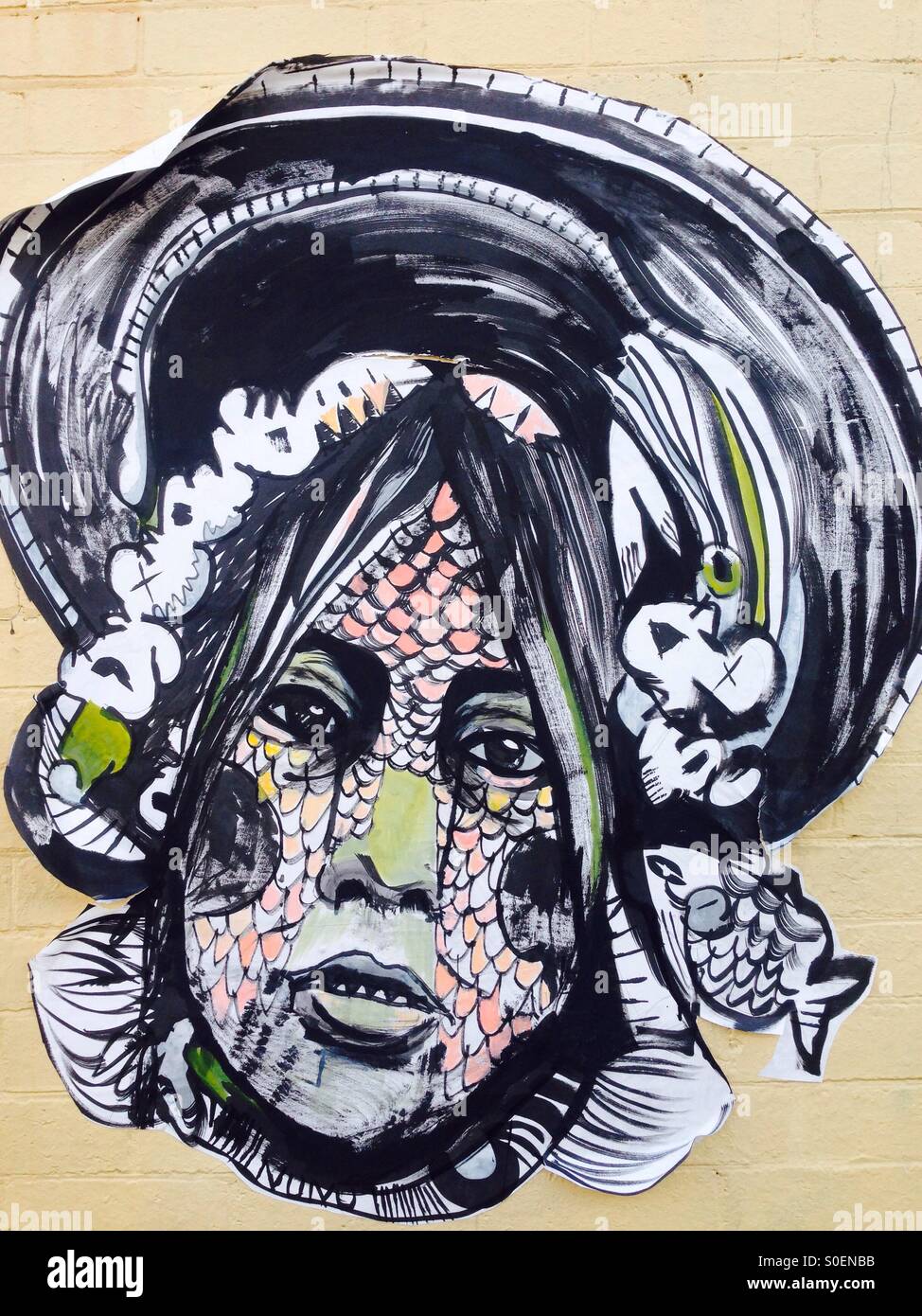 Arte di strada del volto di donna con squame di pesce Foto Stock