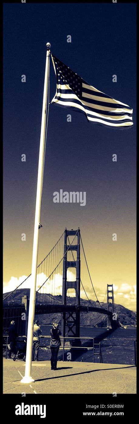 Una bandiera americana presso il Golden Gate Bridge. San Francisco, California, Stati Uniti d'America - Immagine stock catturata con smartphone