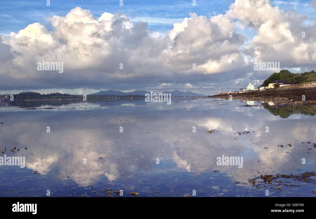 La riflessione di nuvole in Stretto di Menai da Anglesey Foto Stock