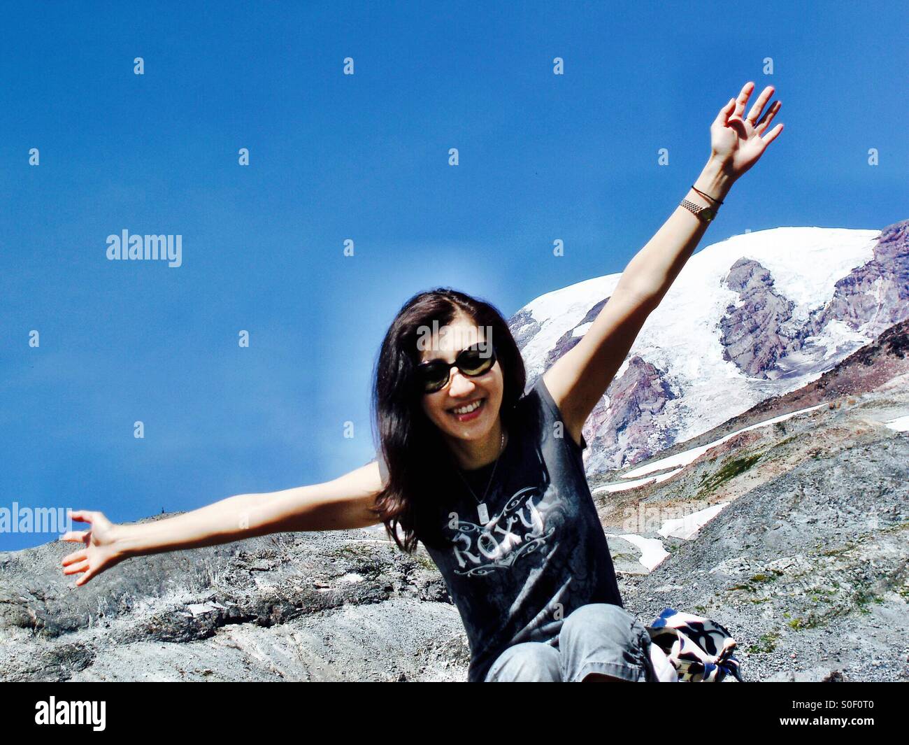 Una giovane donna si diffonde le sue braccia in euforia avvicina alla Mt. Rainier vertice glaciale in agosto. Il Monte Rainier, WA, Stati Uniti d'America. - Immagine stock catturata con smartphone