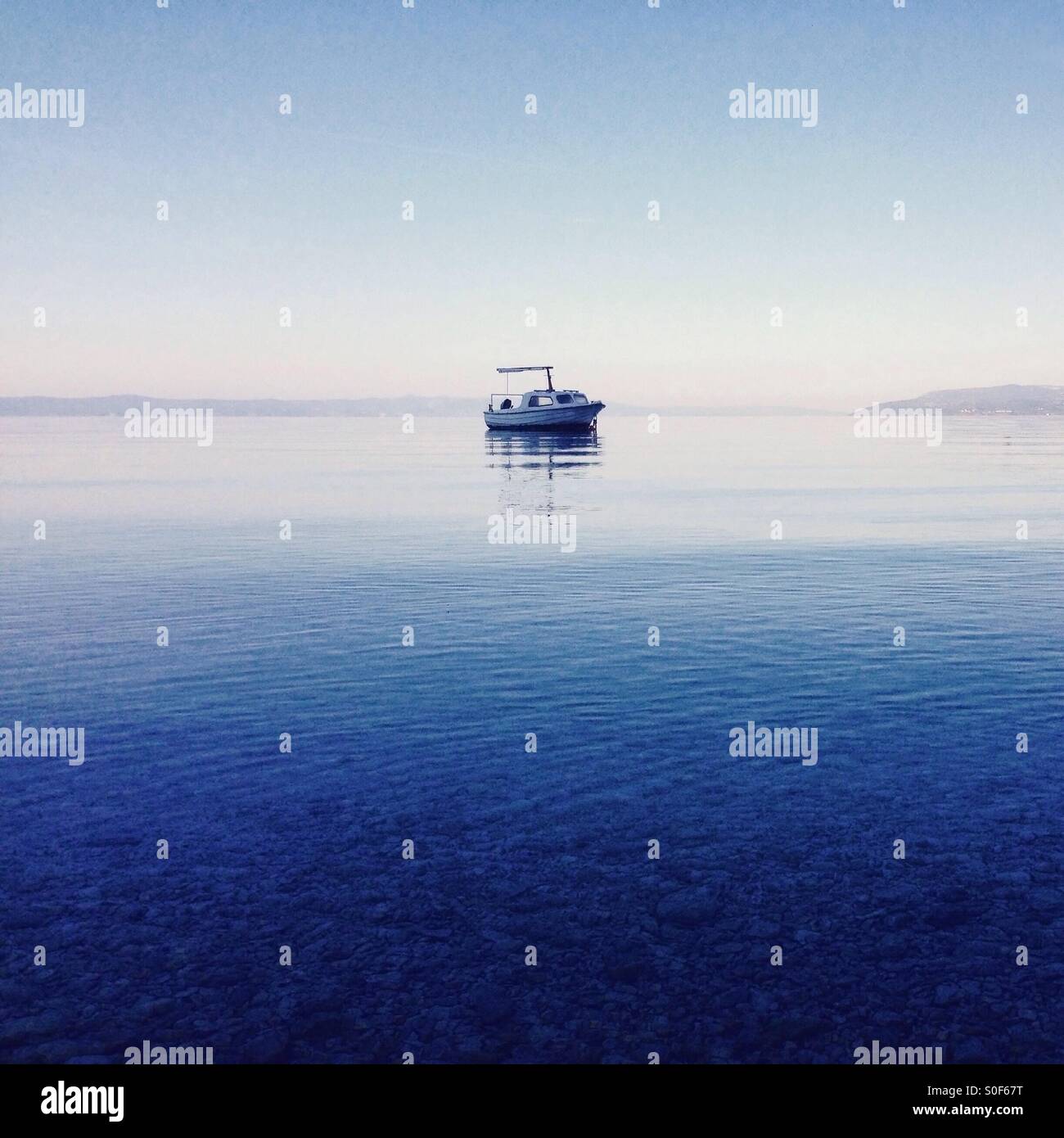 Piccola barca a calma il mare blu Foto Stock