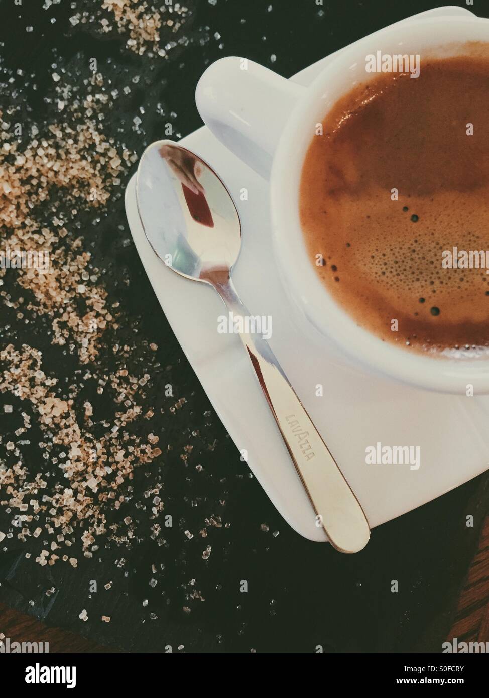 Il caffè del mattino con zucchero fuoriuscito - Immagine stock catturata con smartphone