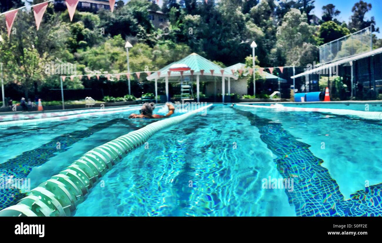 Donna calci con kickboard in esterna olimpionica, piscina di 25 metri. San Francisco Bay Area, California, Stati Uniti d'America. - Immagine stock catturata con smartphone