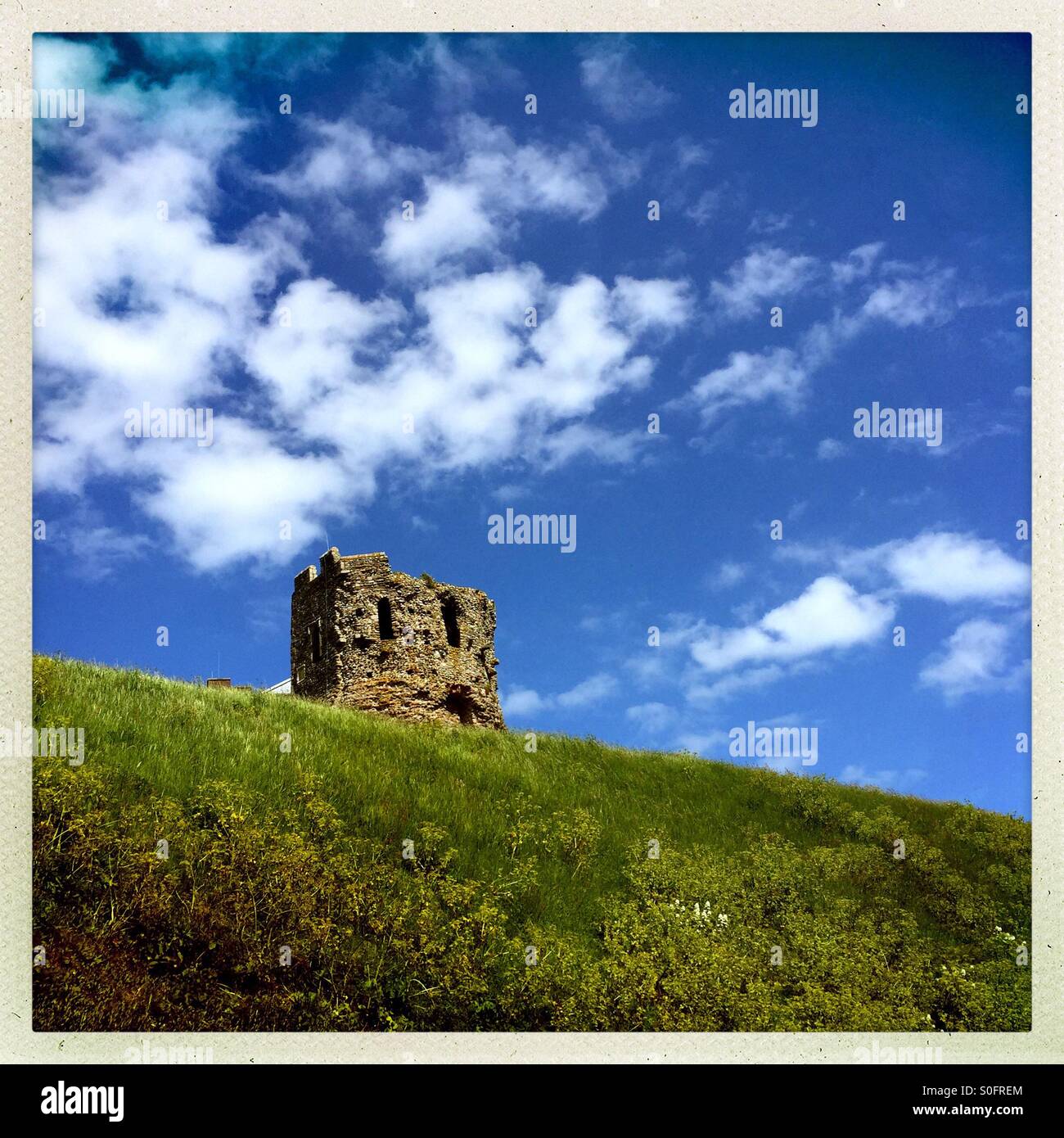 Rovine sulla cima di una ripida collina erbosa Foto Stock