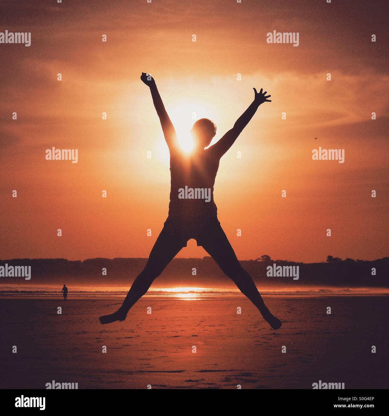 Donna energica, stella salta nella parte anteriore del tramonto. Foto scattata in Australia oltre l'estate. Foto Stock