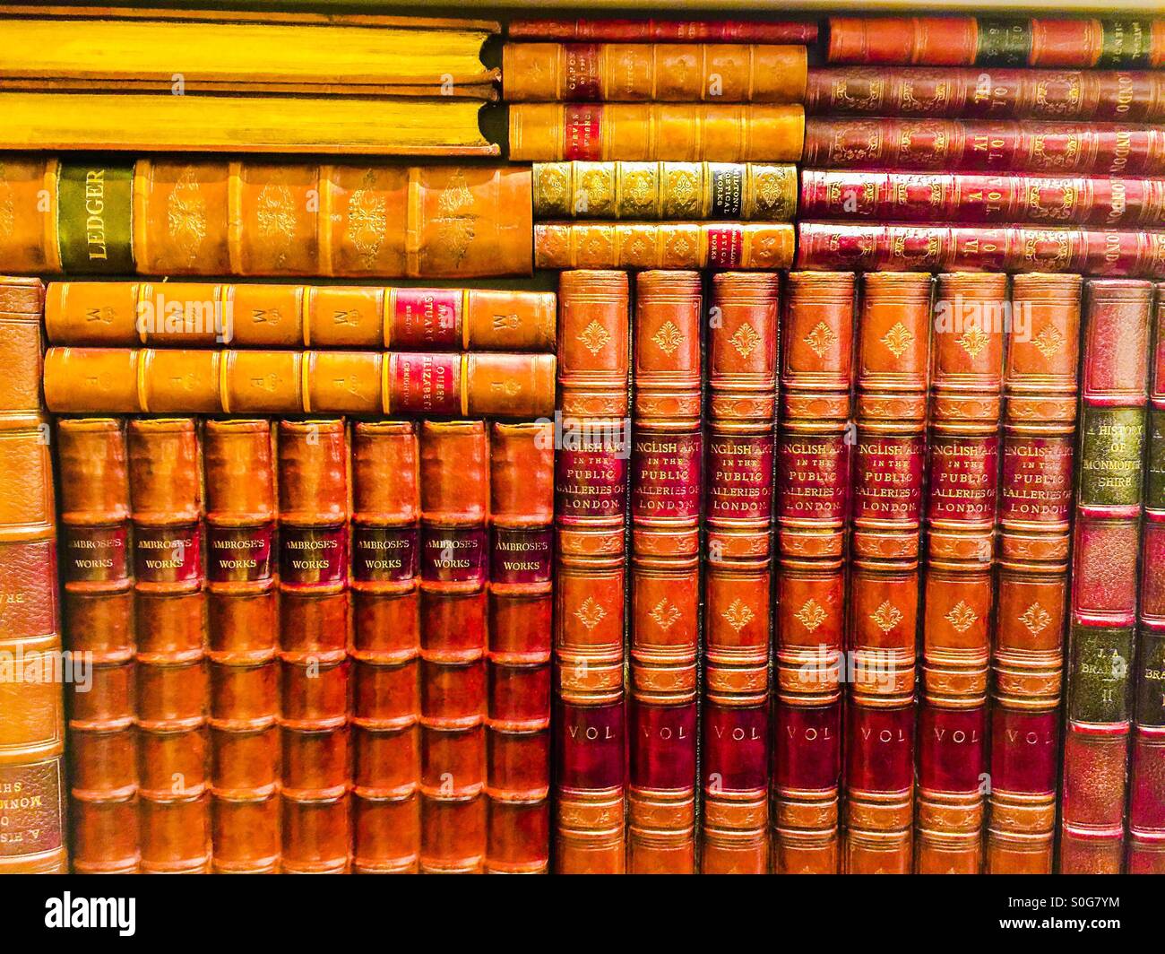 Libri molto vecchi, oversize, rilegati in pelle pregiata, impilati verticalmente e orizzontalmente, Canada. Da un'altra era. - Immagine stock catturata con smartphone
