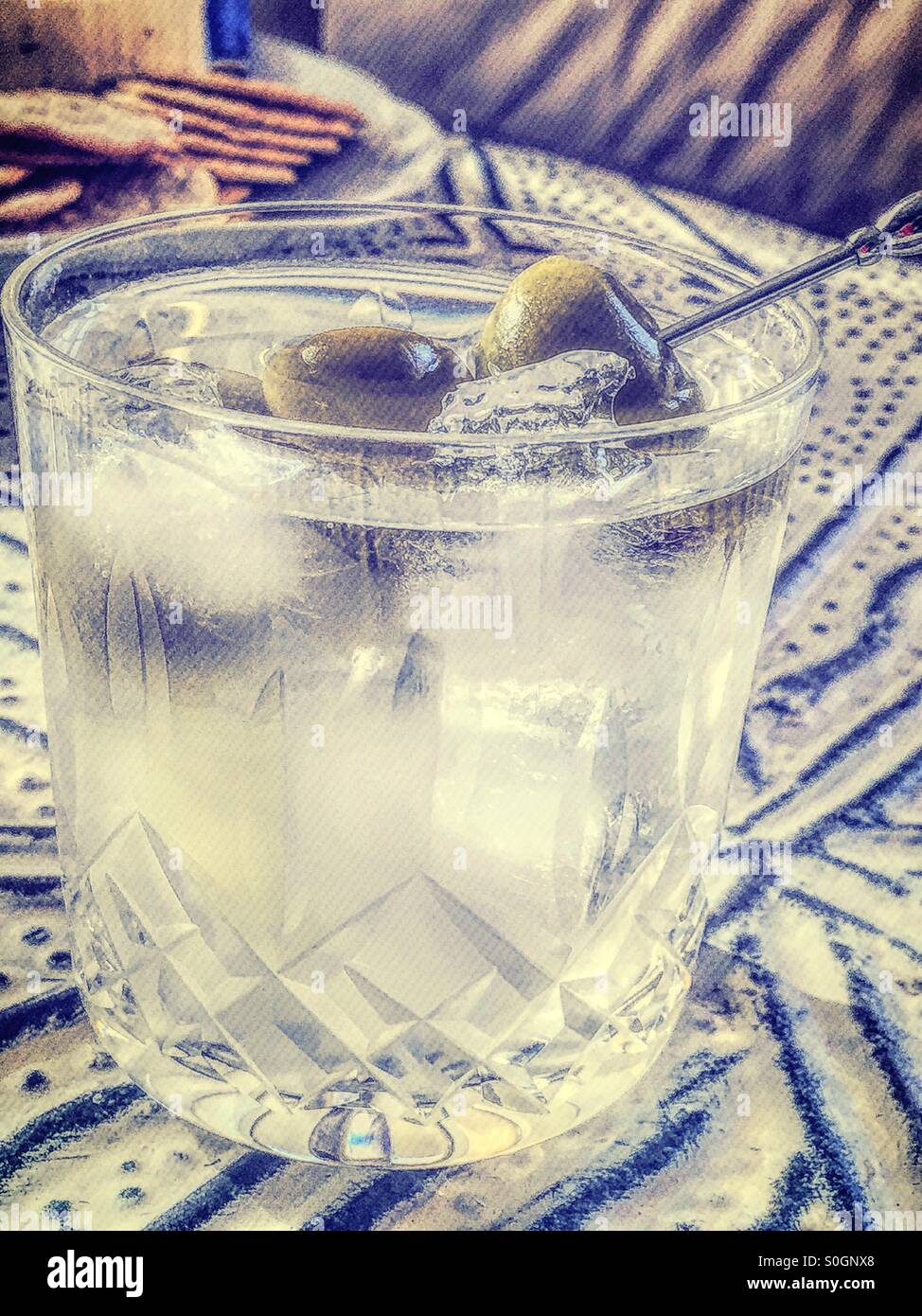 Martini sulle rocce con olive nel bicchiere di cristallo. Foto Stock