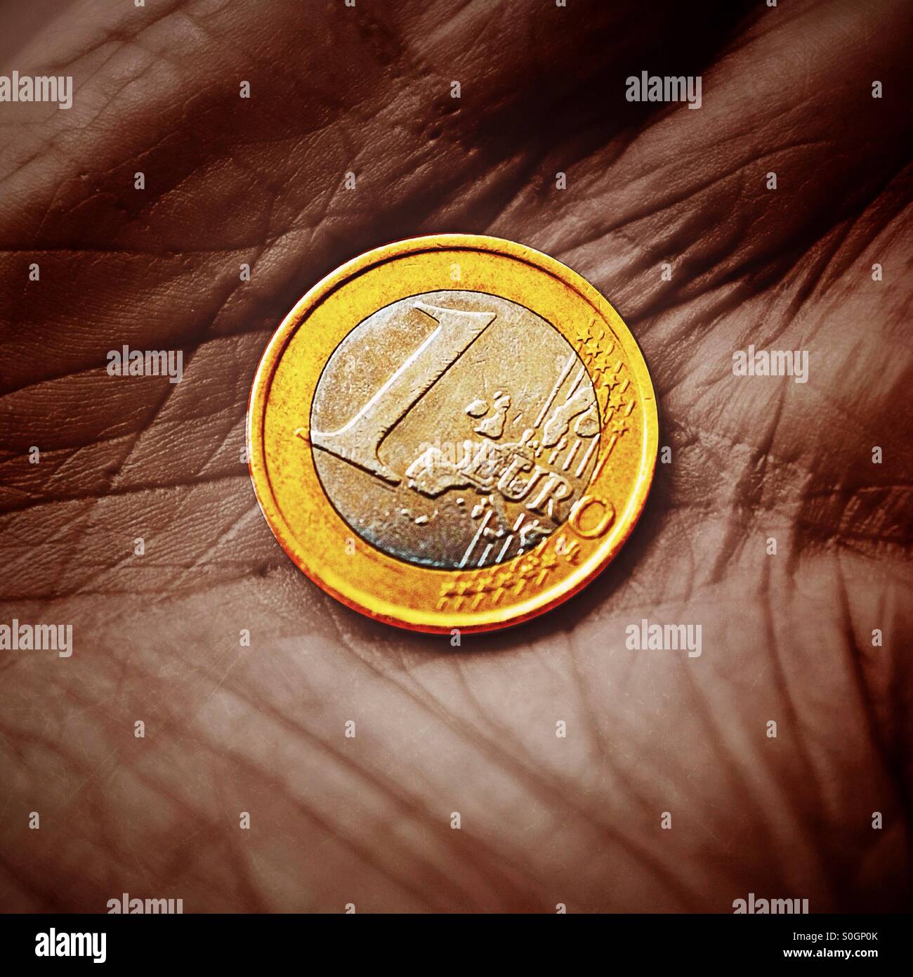 Una chiusura di una moneta in euro in un titolare di pensione o di rendita la mano - Immagine stock catturata con smartphone