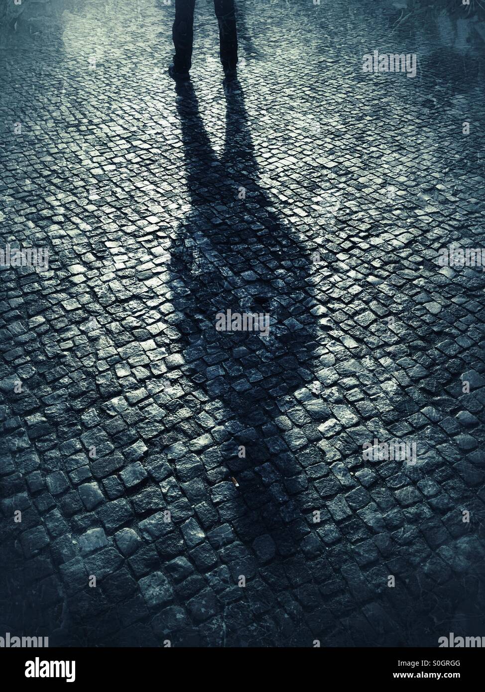 Sinister shadow maschio sul lastricato della strada Foto Stock