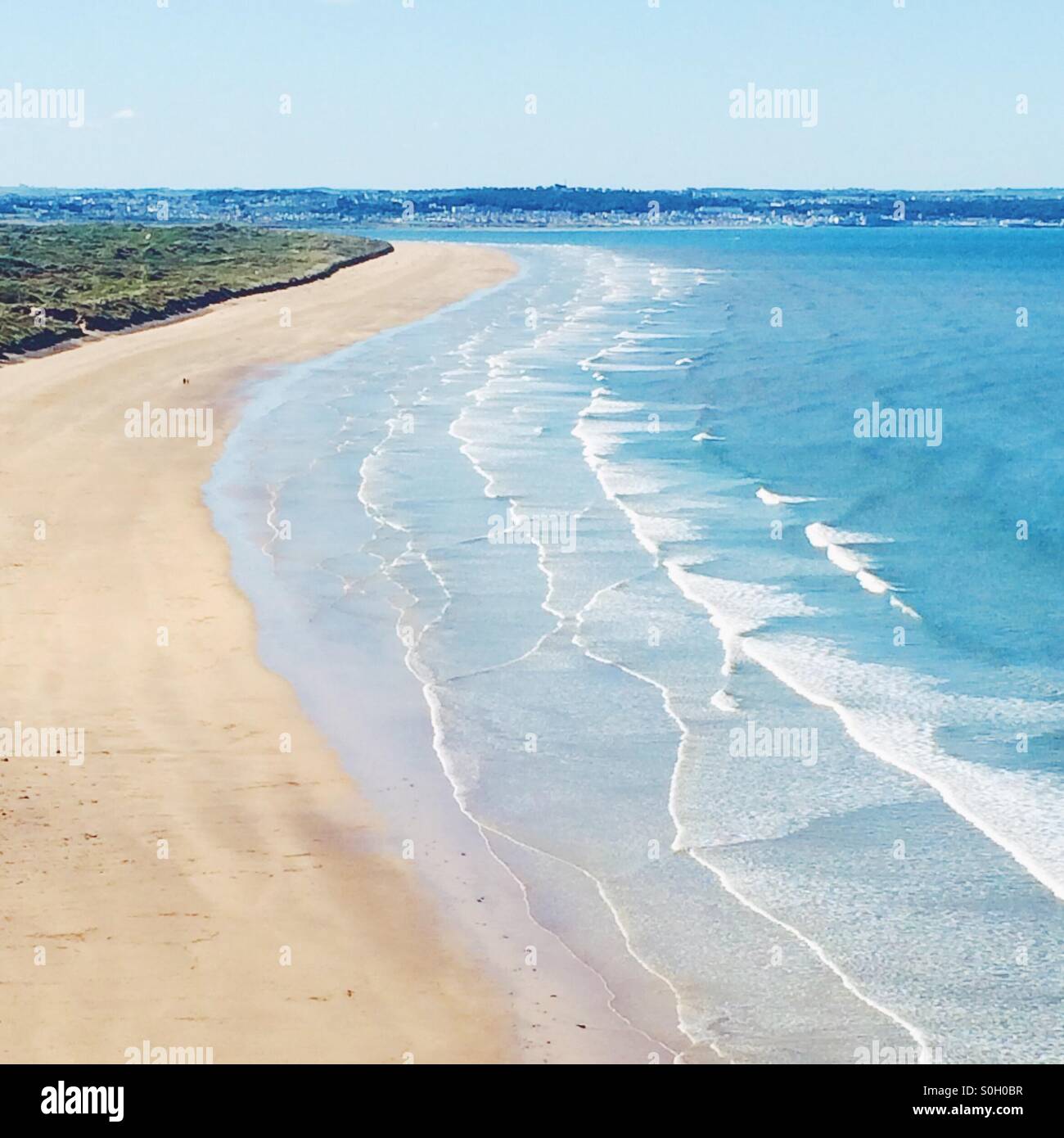 Lunga spiaggia di sabbia con un mare blu in estate. Foto Stock