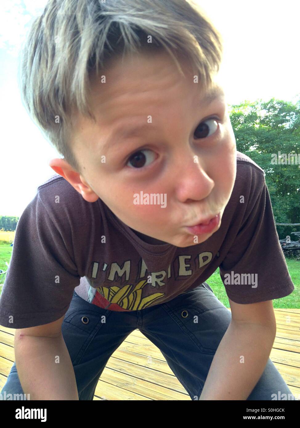 10 anno vecchio ragazzo di piegarsi per un bacio Foto Stock