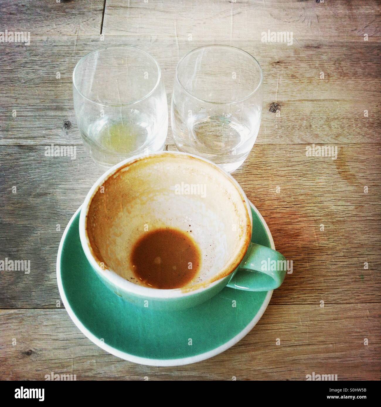 Svuotare tazza da caffè e bicchieri di acqua su un tavolo - Immagine stock catturata con smartphone