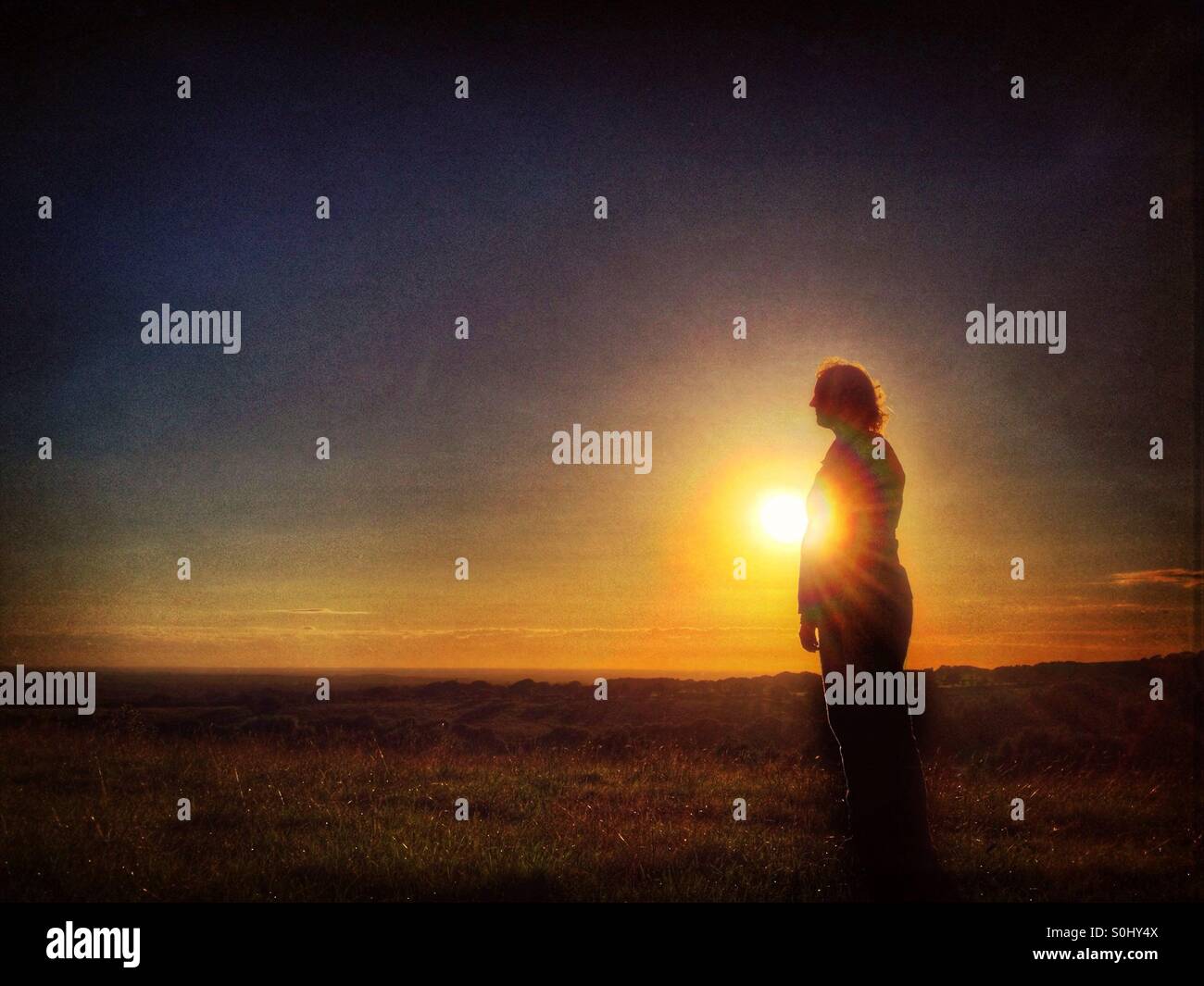 La donna da sola nel paesaggio al tramonto Foto Stock