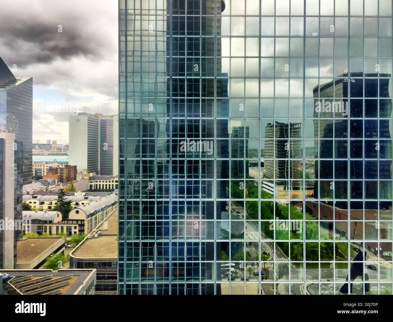 Cielo drammatico e riflessioni in edificio per uffici di Windows - Immagine stock catturata con smartphone