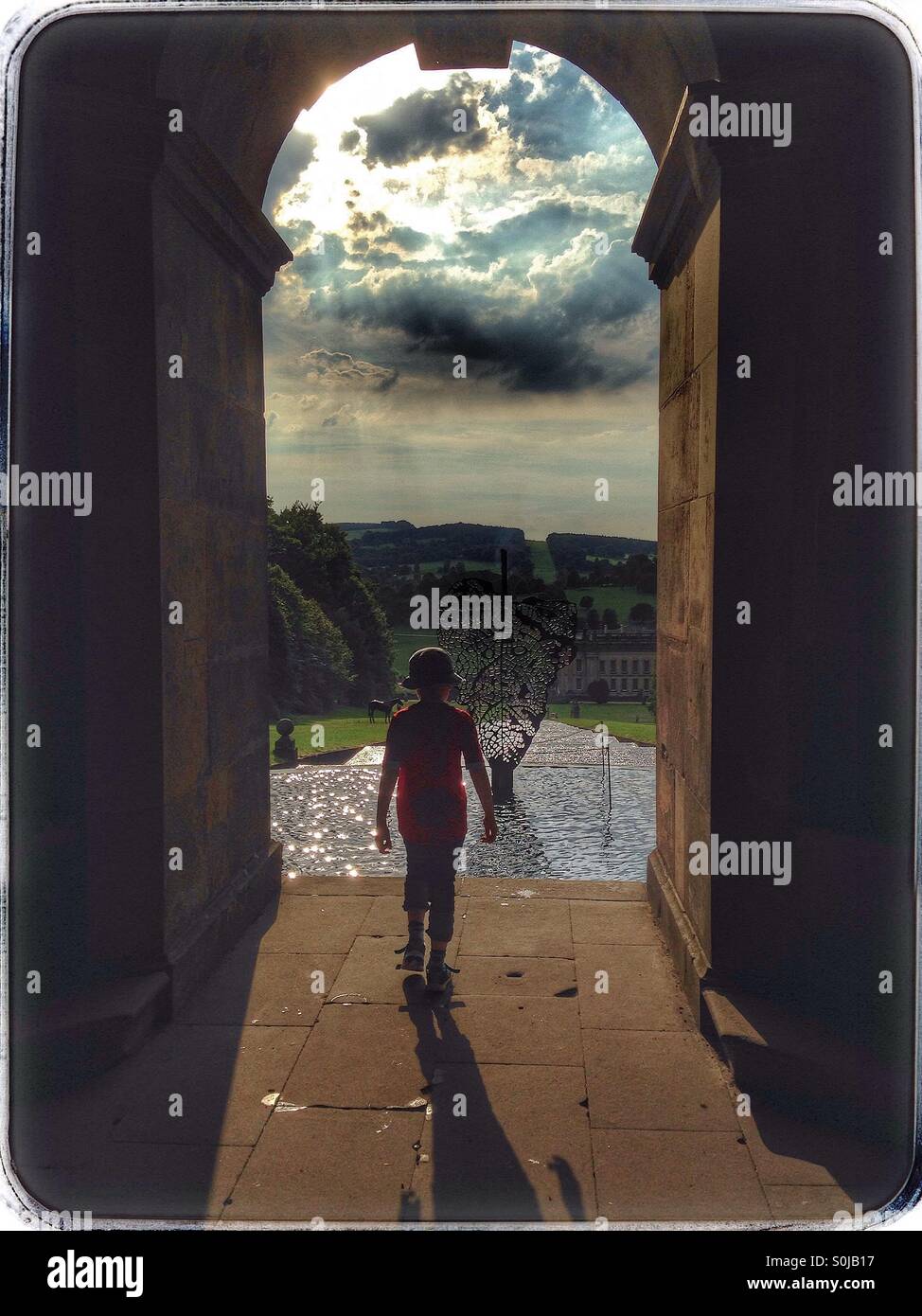 Ragazzo in piedi in un arco Foto Stock