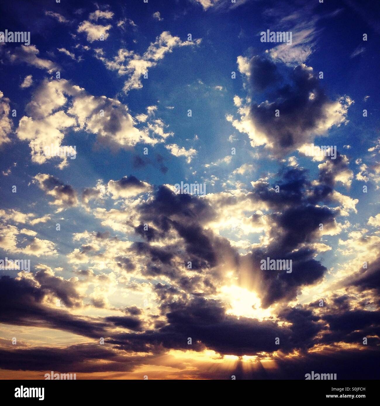 Raggi del sole attraverso le nuvole sullo sfondo Foto Stock