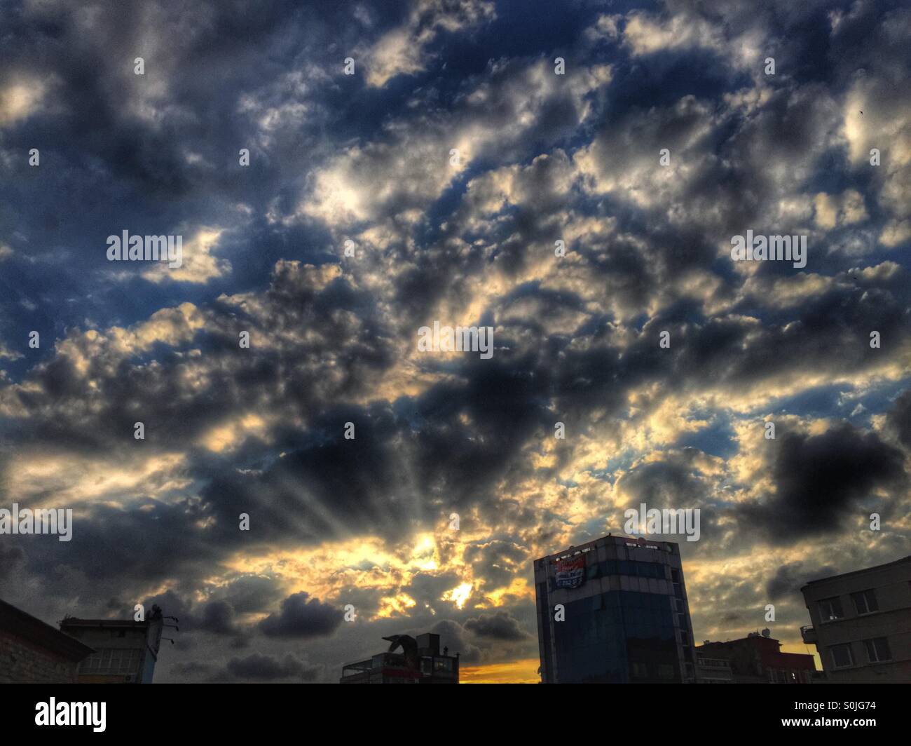 Tramonto dietro le nuvole con raggi - Piazza Taksim Istanbul - Turchia Foto Stock