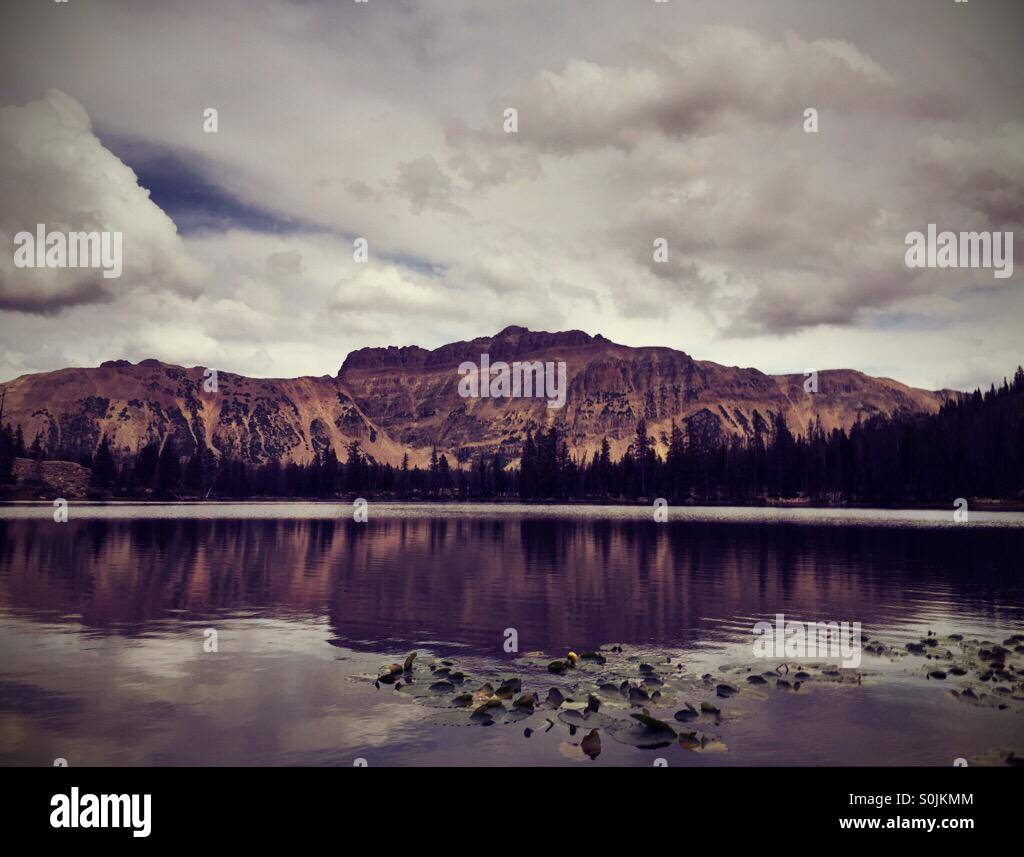 Colore- versione filtrata del paesaggio fotografico delle montagne Uinta riflessa in Ruth's lake in Uinta National Forest. Foto Stock