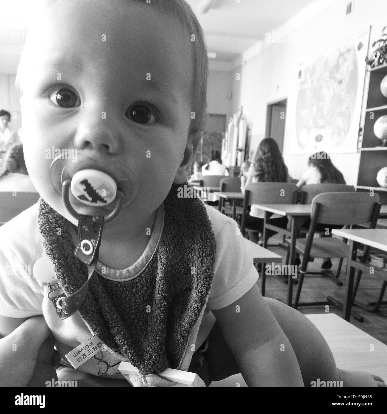 Bambino seduto nel suo gemello classe il primo giorno di scuola Foto Stock
