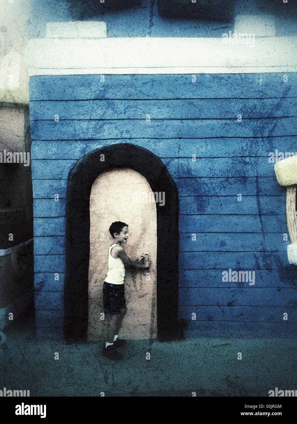 7 anni vecchio ragazzo aprendo la porta Foto Stock