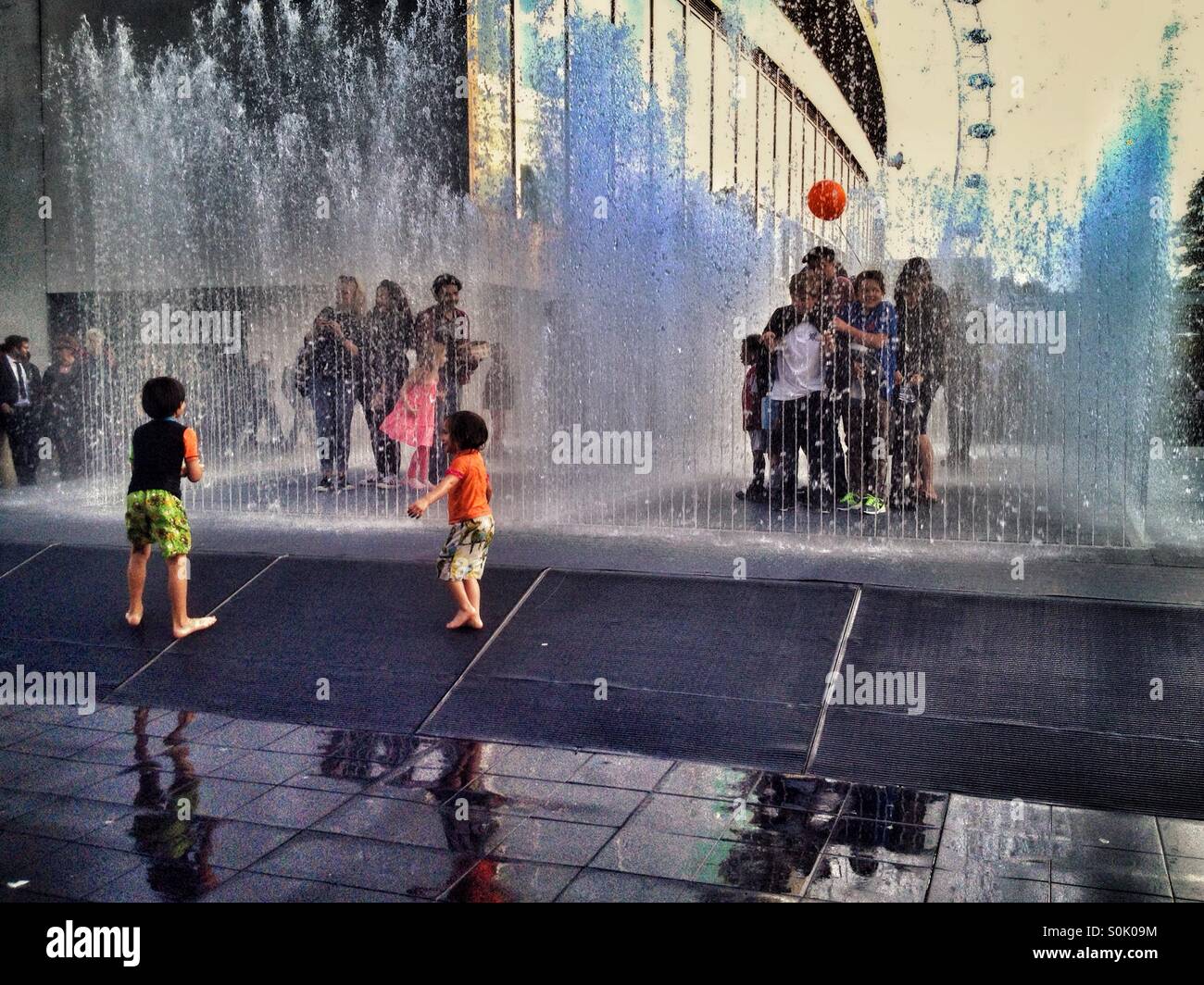 Bambini che giocano nella fontana al di fuori del Royal Festival Hall presso il centro di Southbank a Londra REGNO UNITO Foto Stock