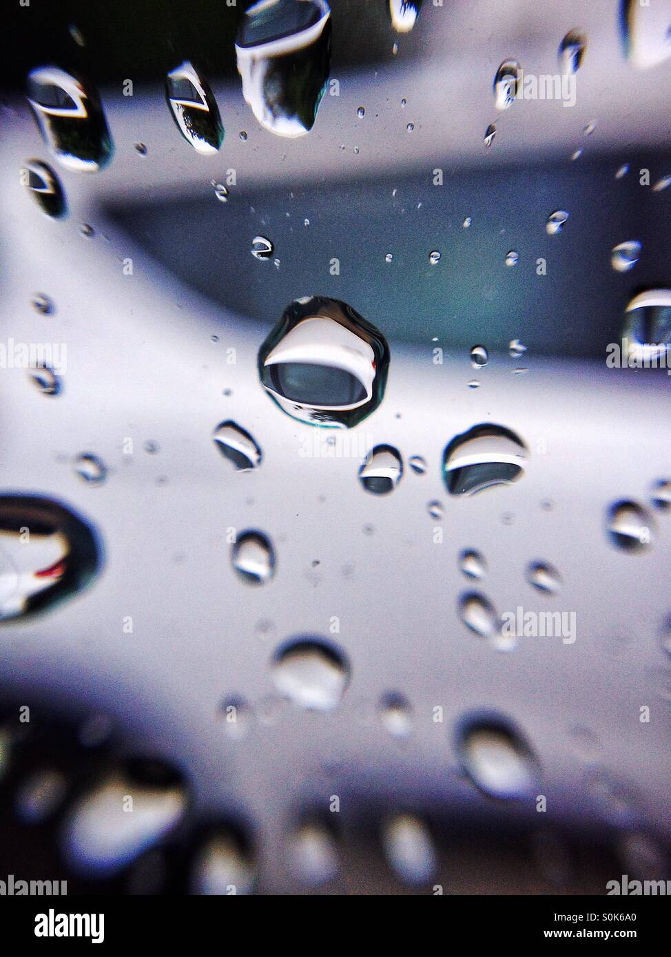 Le gocce di pioggia sul finestrino di un'automobile Foto Stock