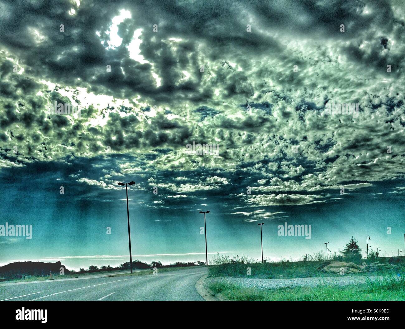 I raggi del sole attraverso il picco di nuvole Foto Stock