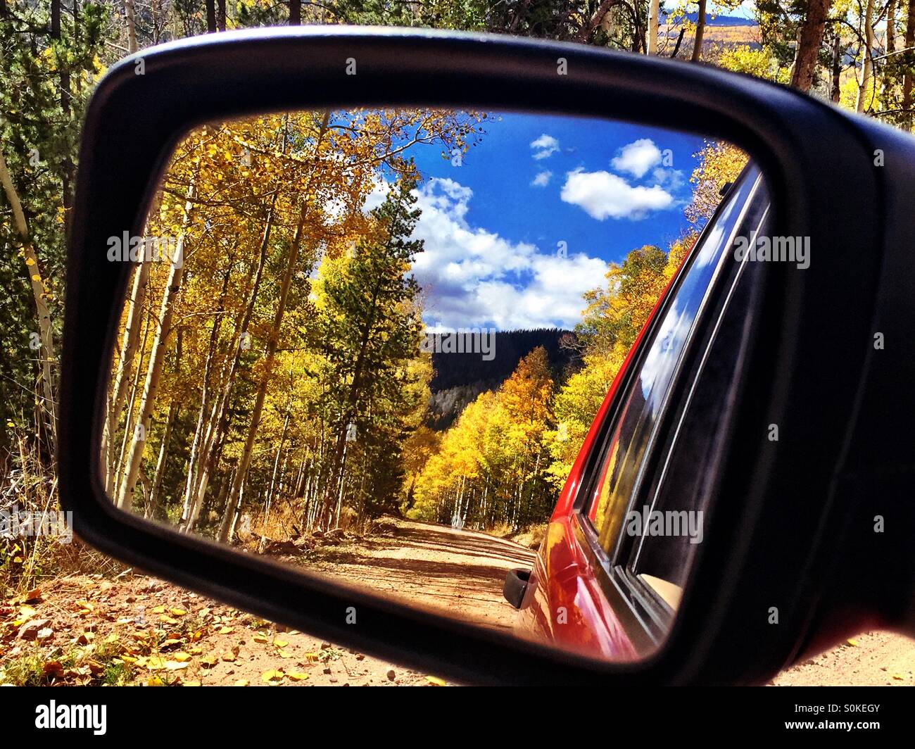 Aspen alberi che linea il mirror Lake in autostrada in Utah sono riflesse in un SUV specchietto retrovisore. Foto Stock