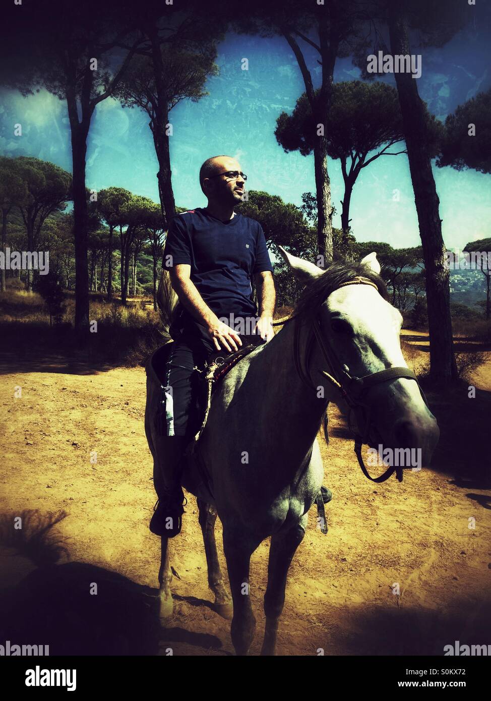 La mezza età uomo a cavallo nella foresta - Immagine stock catturata con smartphone