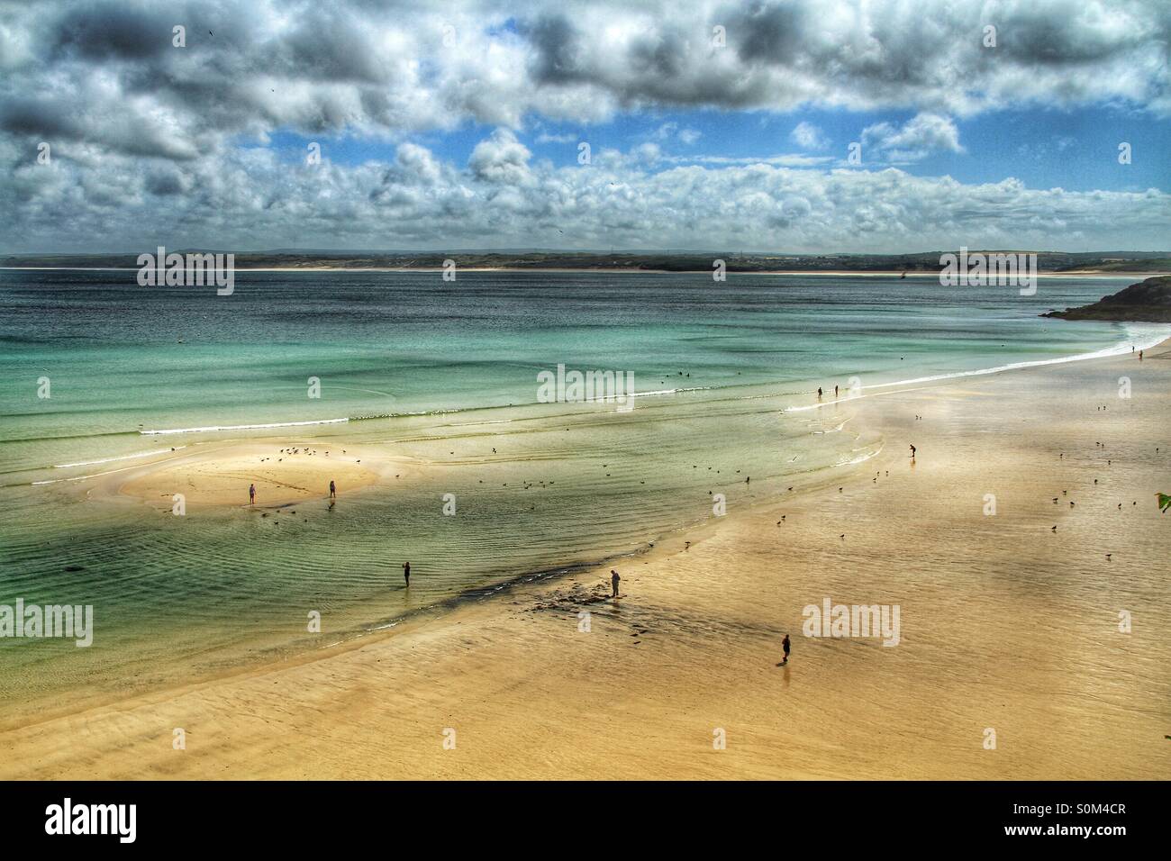 Una circolare sandbank appare come la marea si spegne su di una spiaggia di sabbia. Foto Stock