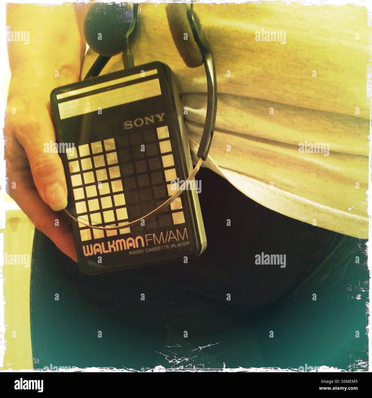 Donna che mantiene il Walkman radio cassette personal music player utilizzato nei giorni prima di IPOD MP 3 giocatori Foto Stock