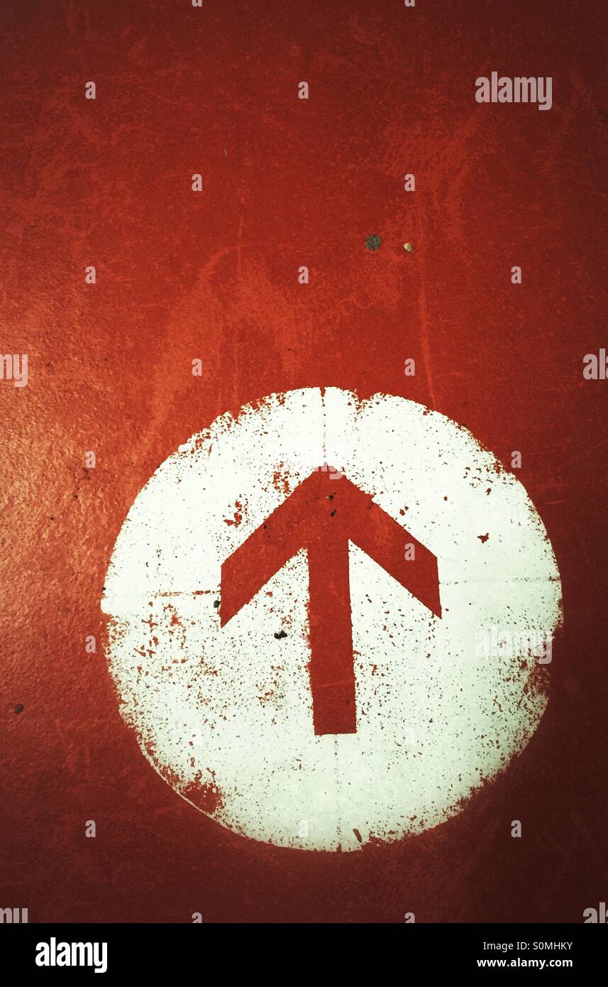 Una freccia arancione in un cerchio bianco - Immagine stock catturata con smartphone