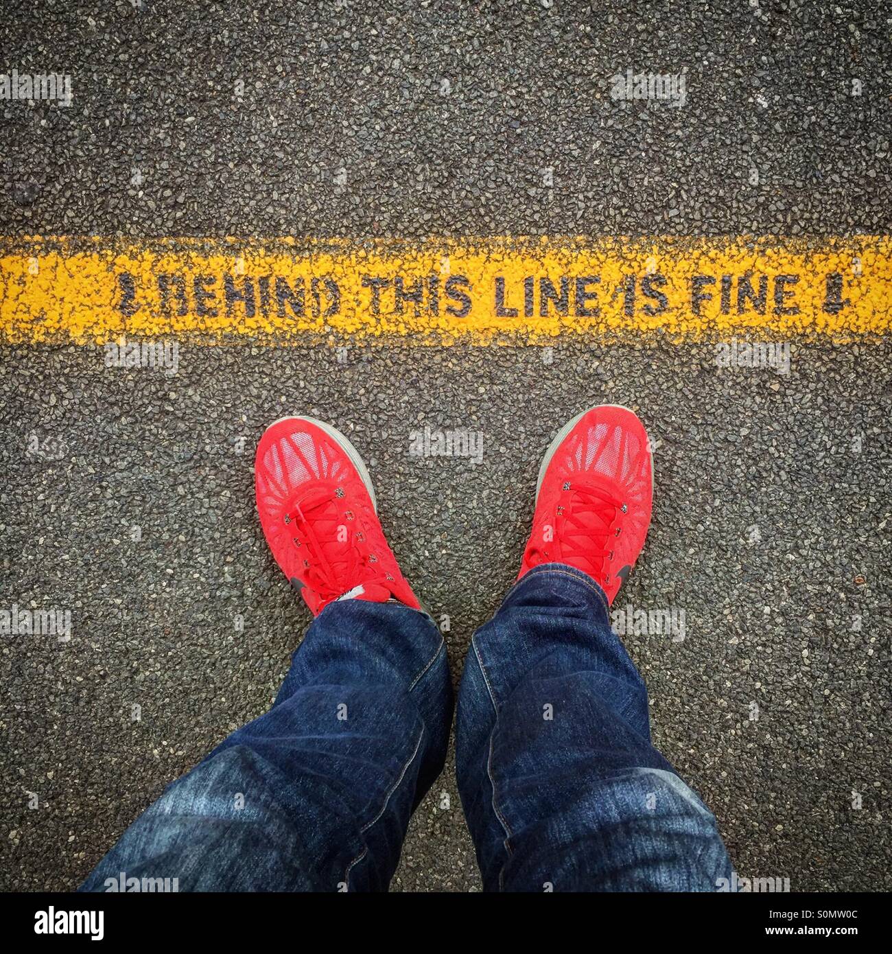 Piedi rossa accanto a un cartello di avviso Foto Stock